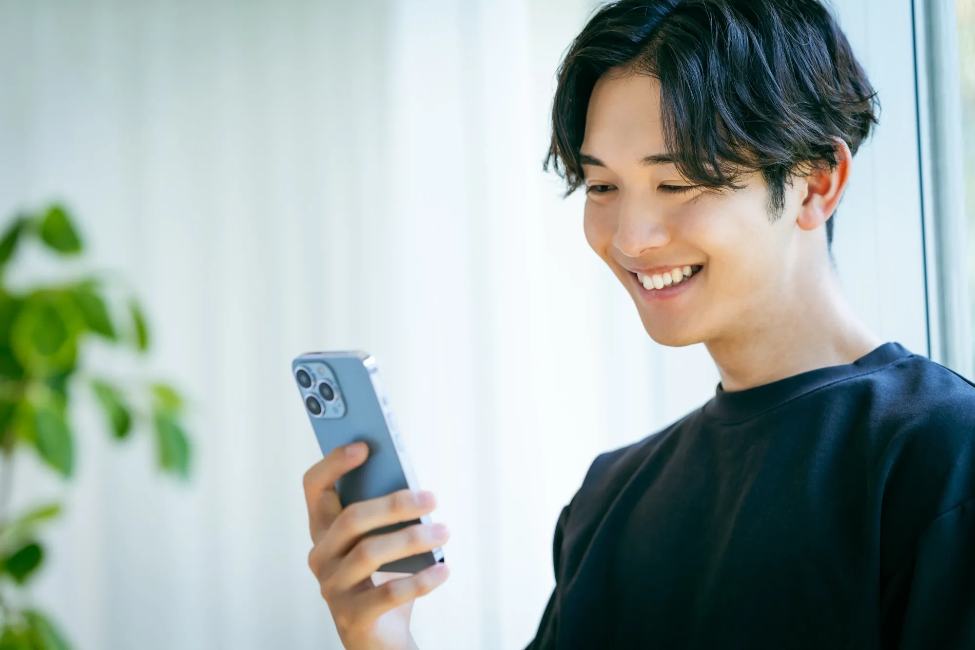 スマートフォンを見ながら問い合わせを検討するビジネスパーソン